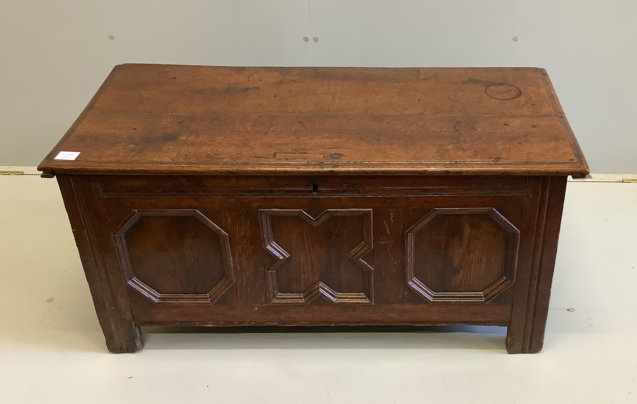A small 17th century oak coffer with moulded geometric panelled front, width 108cm, depth 49cm, height 52cm